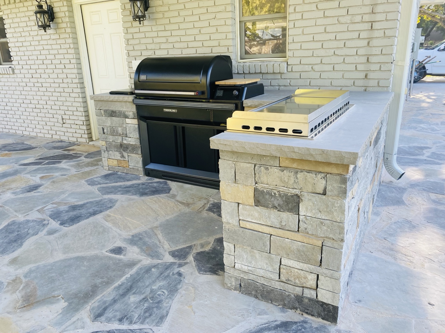 Custom stone outdoor kitchen constructed by First Garden Landscaping