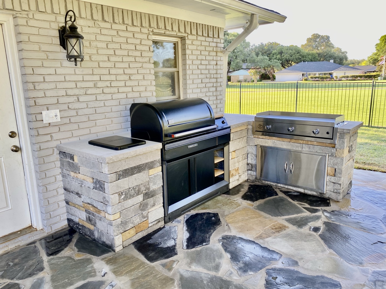 Custom stone outdoor kitchen by First Garden Landscaping