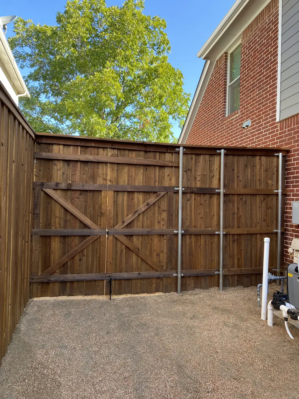 Wood privacy fence with gate beside a walkway