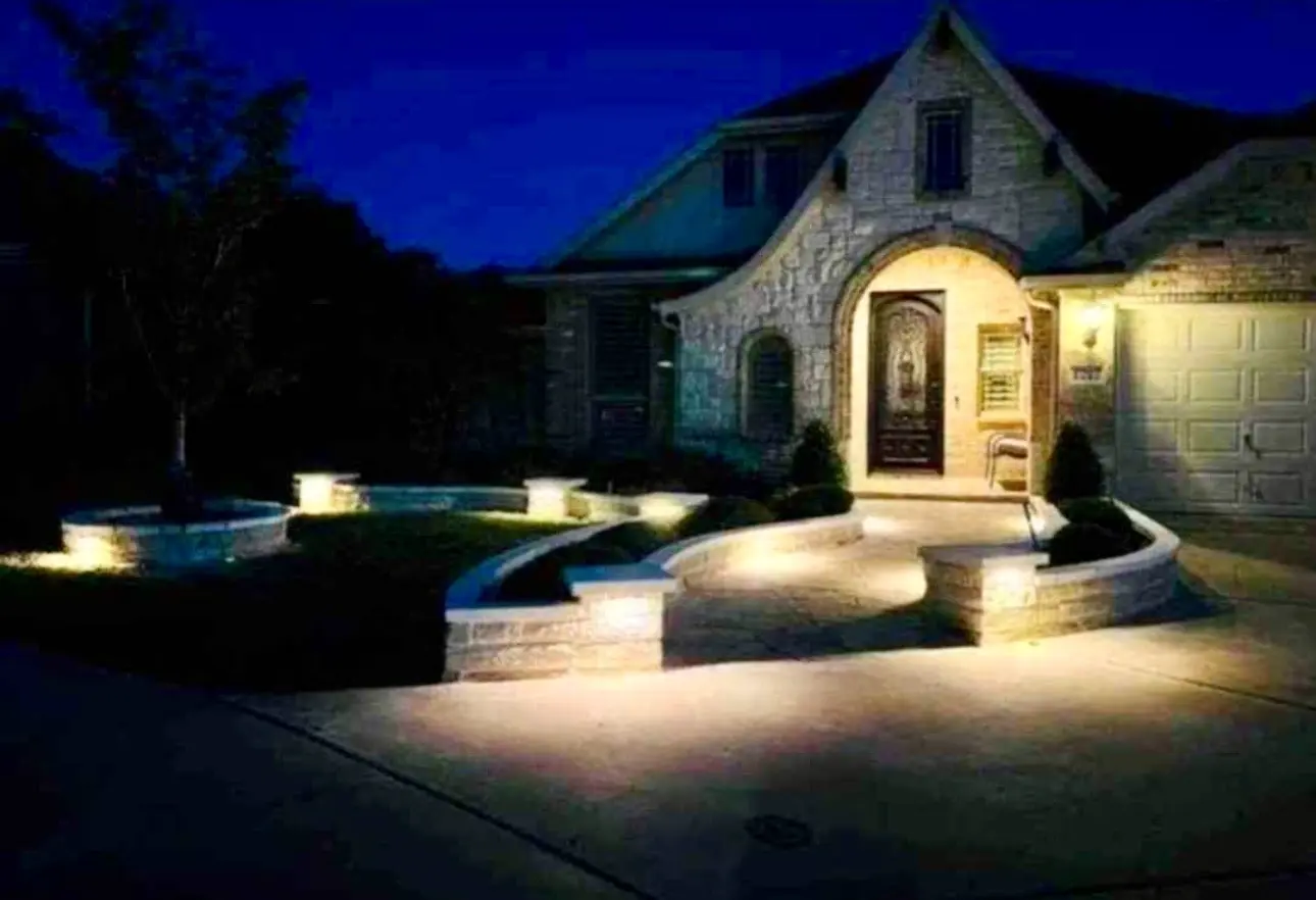 Landscape lighting illuminating a brick home and walkway