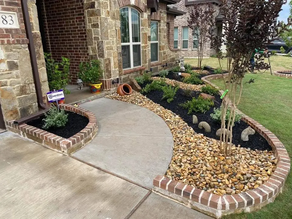 Landscaped yard with curved stone walkway and planted beds