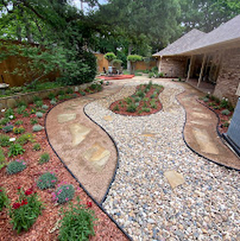 Residential garden design with curved stone walkway, rock beds and planted borders