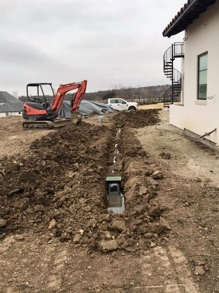Residential drainage installation with catch basin and excavated trench