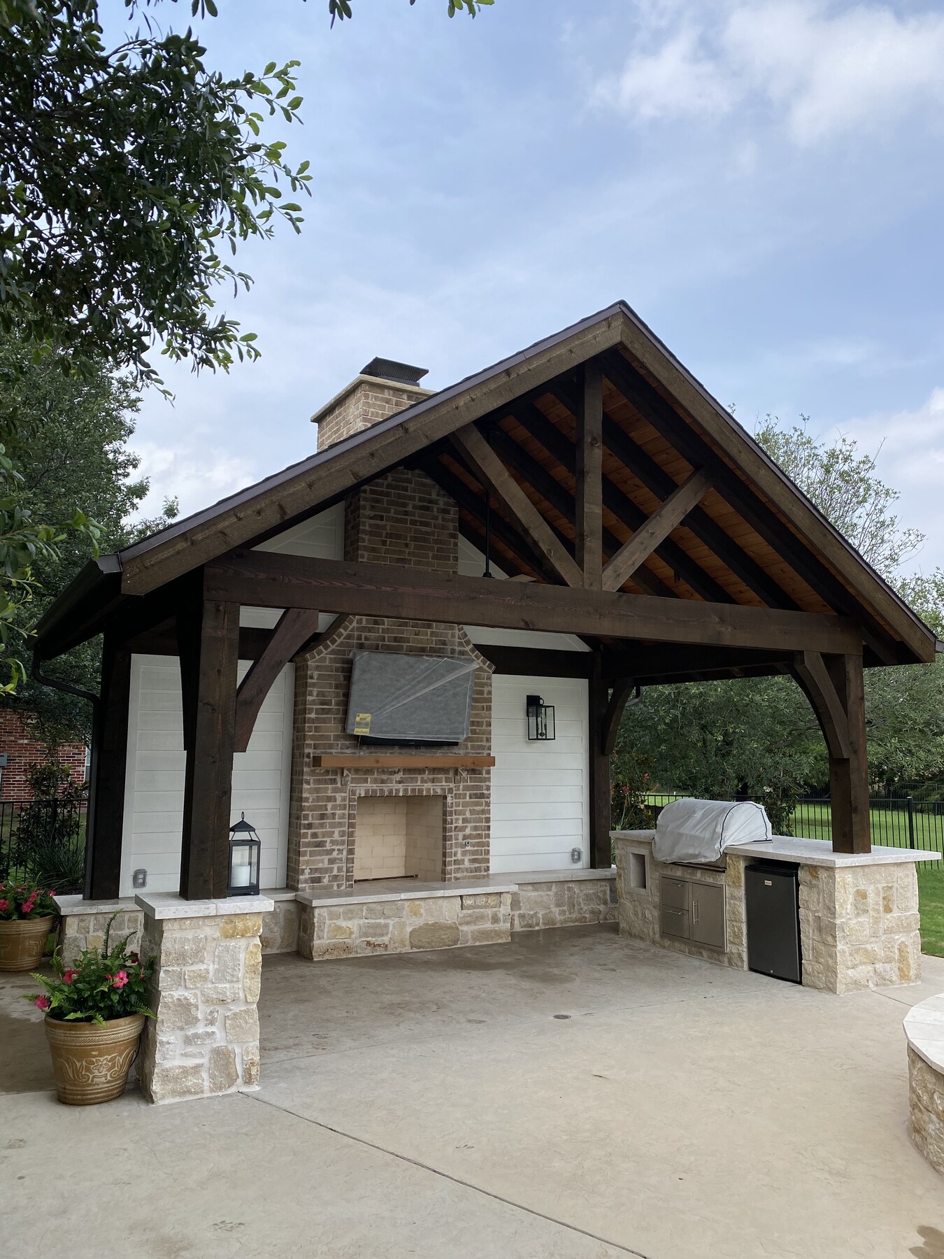 Covered patio with wood gable structure and outdoor fireplace