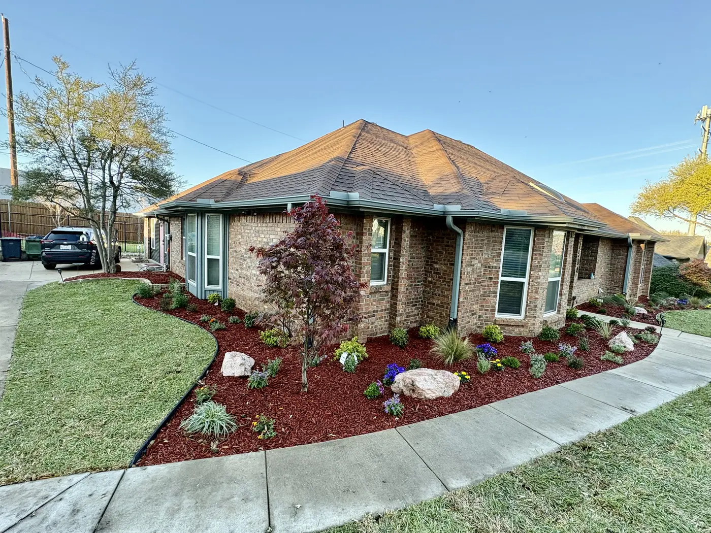 Mulch and rock landscape beds beside a residential lawn