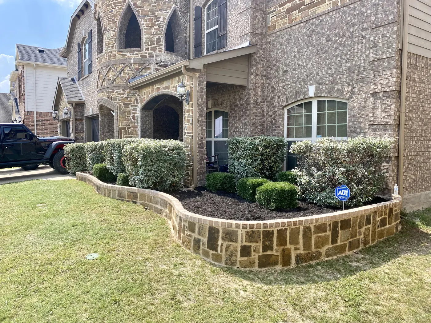 Curved stone retaining wall around a residential landscape bed