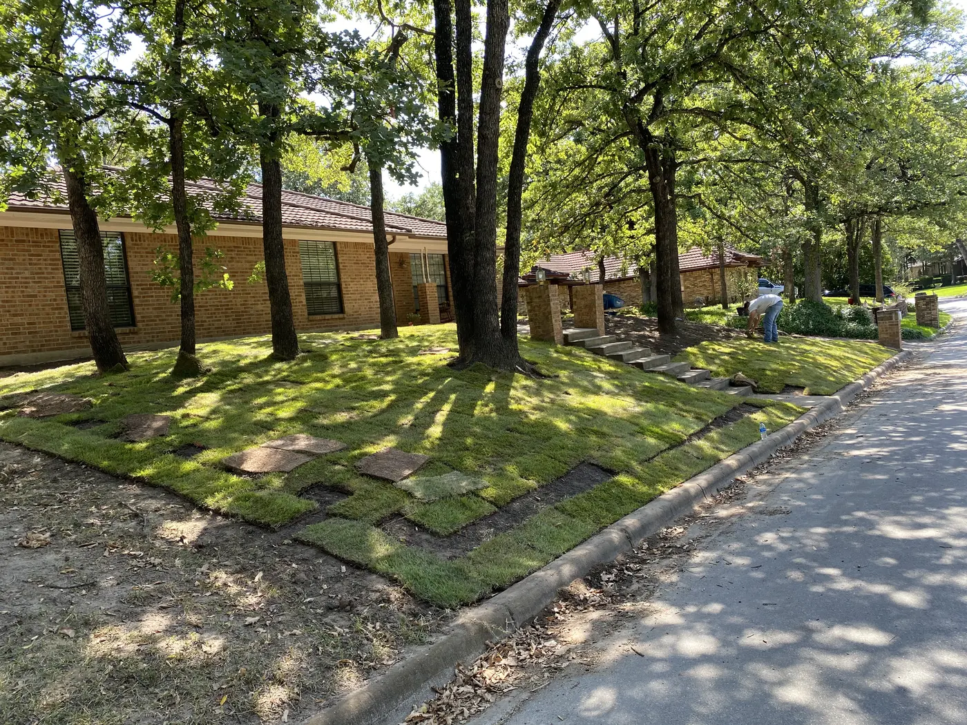 Residential lawn and soil preparation near a covered patio